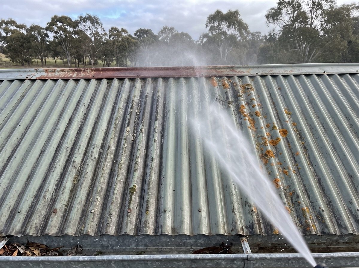 A corrugated metal roof being washed down