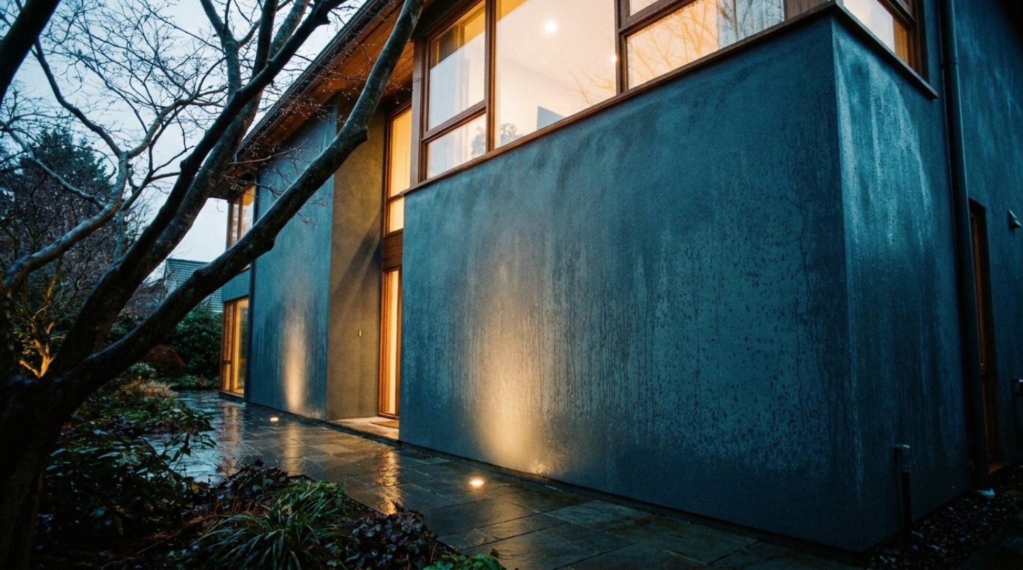 A home at dusk with clean, brightly lit glass across the front